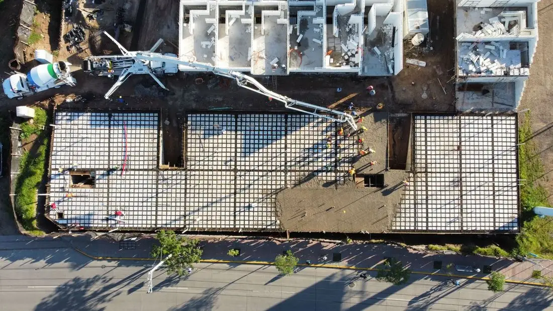 Aerial view of a reinforced slab being poured with a concrete pump