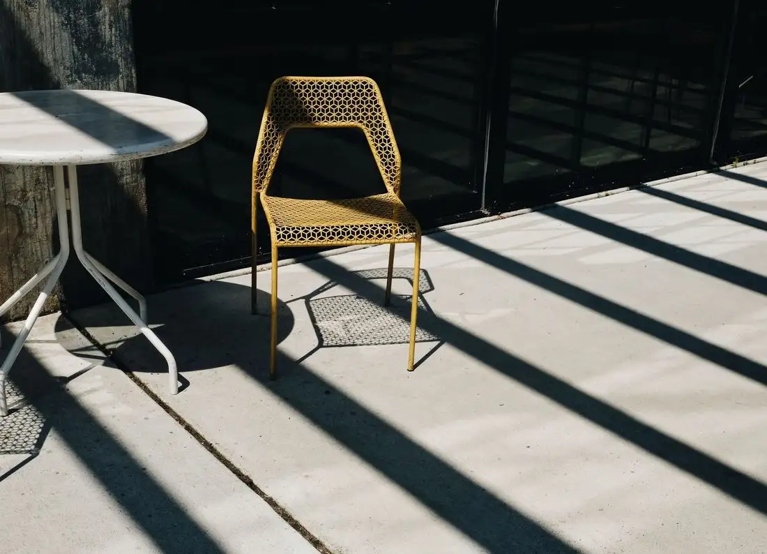 Covered concrete patio with strong afternoon shadows across it